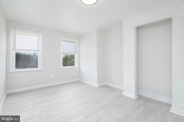 empty room with light hardwood / wood-style flooring