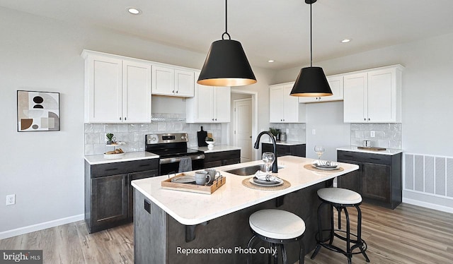 kitchen with backsplash, an island with sink, and light hardwood / wood-style floors