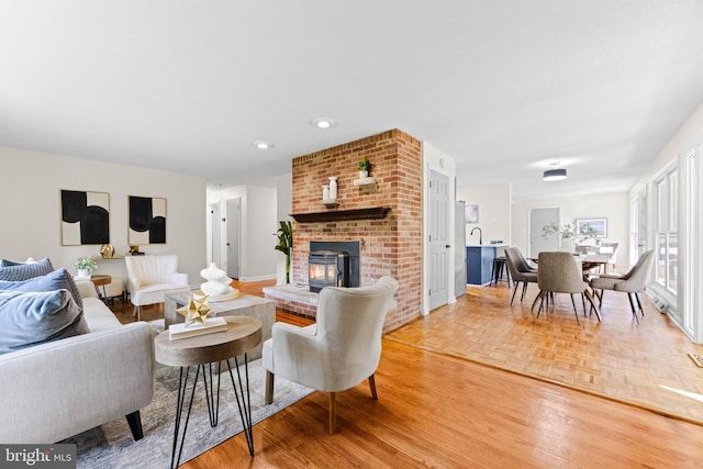 living room featuring wood-type flooring and a brick fireplace