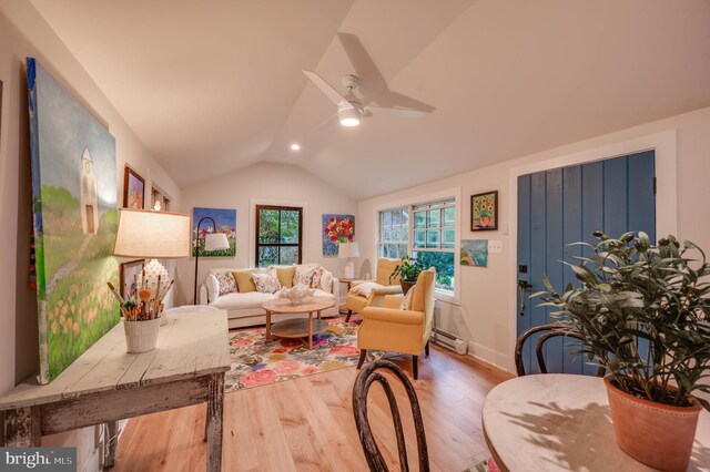 living room featuring ceiling fan, baseboard heating, wood-type flooring, and vaulted ceiling