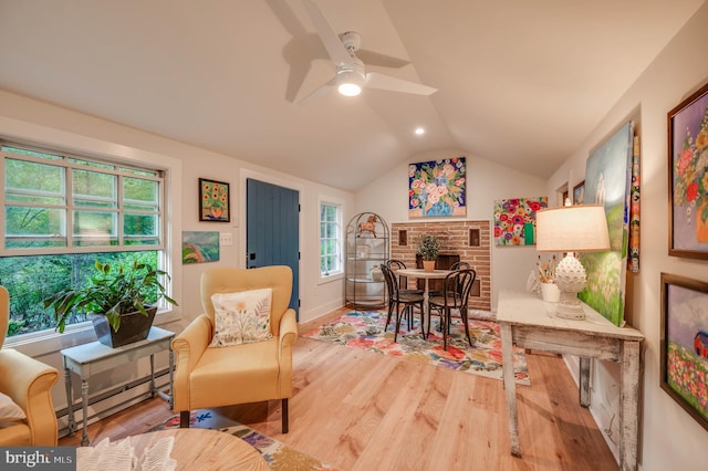 interior space featuring ceiling fan, lofted ceiling, a baseboard heating unit, and wood-type flooring