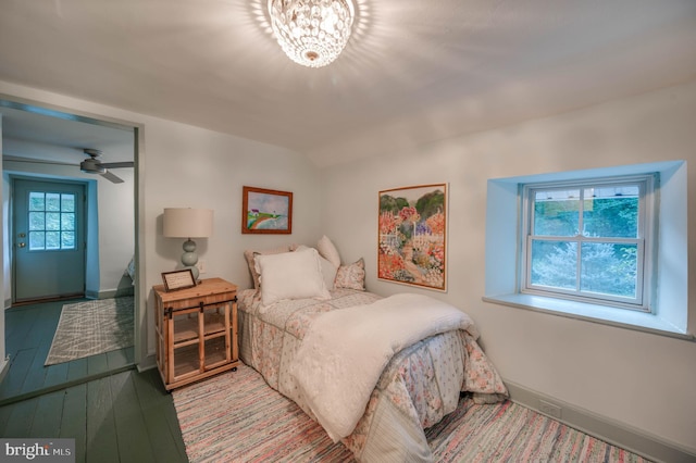 bedroom featuring wood-type flooring and an inviting chandelier