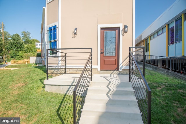 doorway to property with a lawn