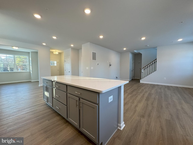 kitchen featuring dark hardwood / wood-style flooring, a kitchen island, and gray cabinetry