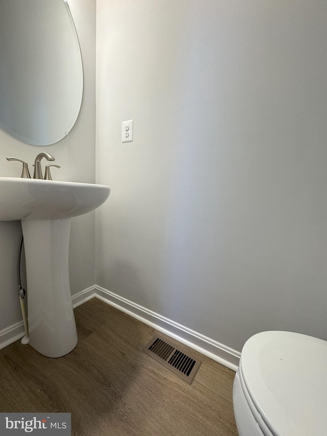 bathroom featuring hardwood / wood-style floors and toilet