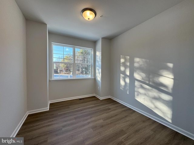 empty room with dark wood-type flooring