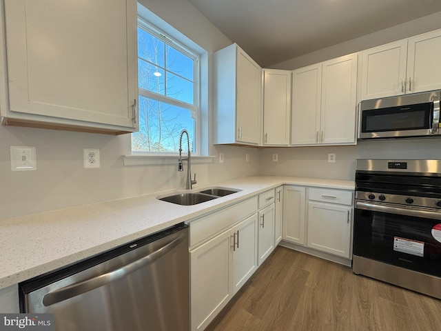 kitchen with white cabinetry, sink, hardwood / wood-style flooring, and appliances with stainless steel finishes