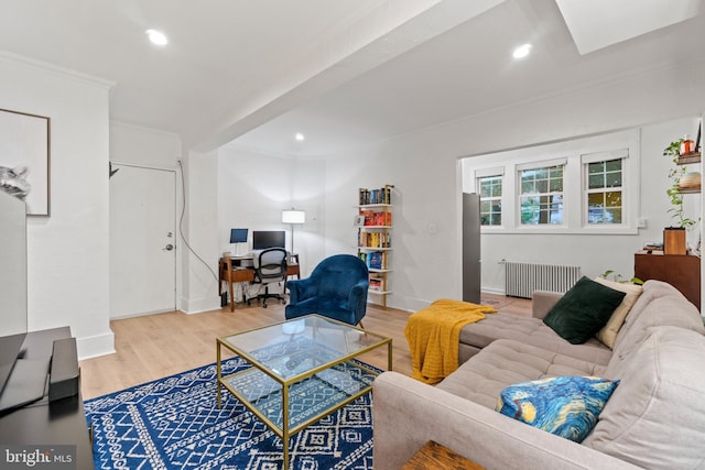 living room with light hardwood / wood-style floors, ornamental molding, and radiator heating unit