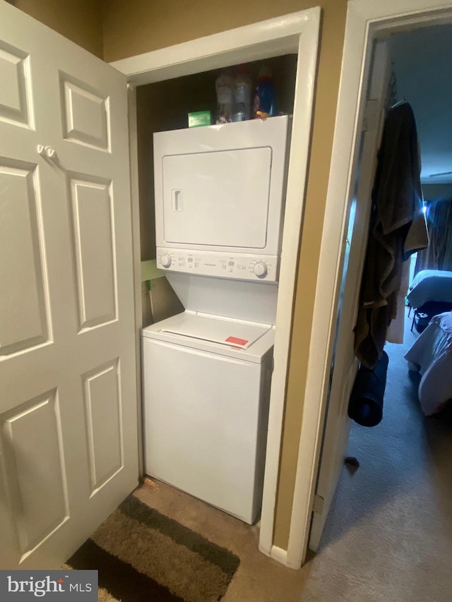 washroom with carpet flooring and stacked washer / dryer