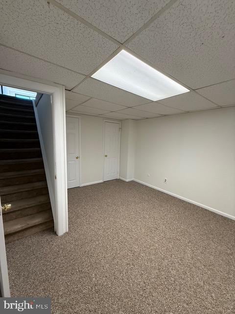 basement featuring carpet flooring and a drop ceiling