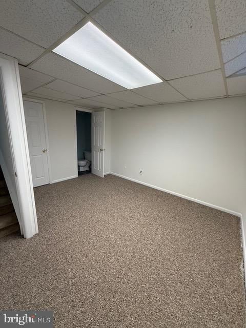 basement with a drop ceiling and carpet