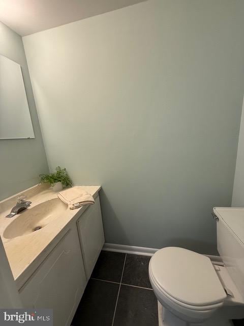 bathroom with tile patterned flooring, vanity, and toilet