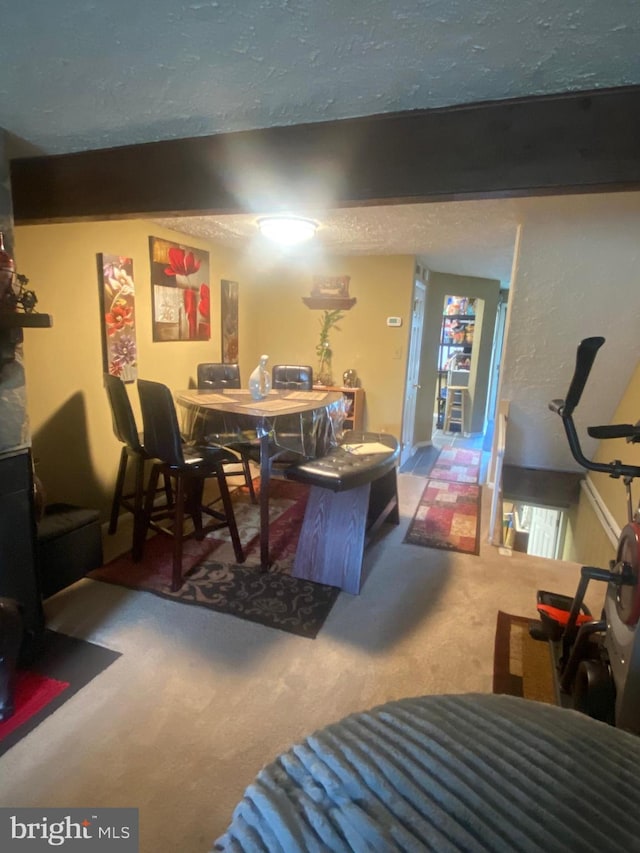 dining space featuring beamed ceiling, a textured ceiling, and carpet floors