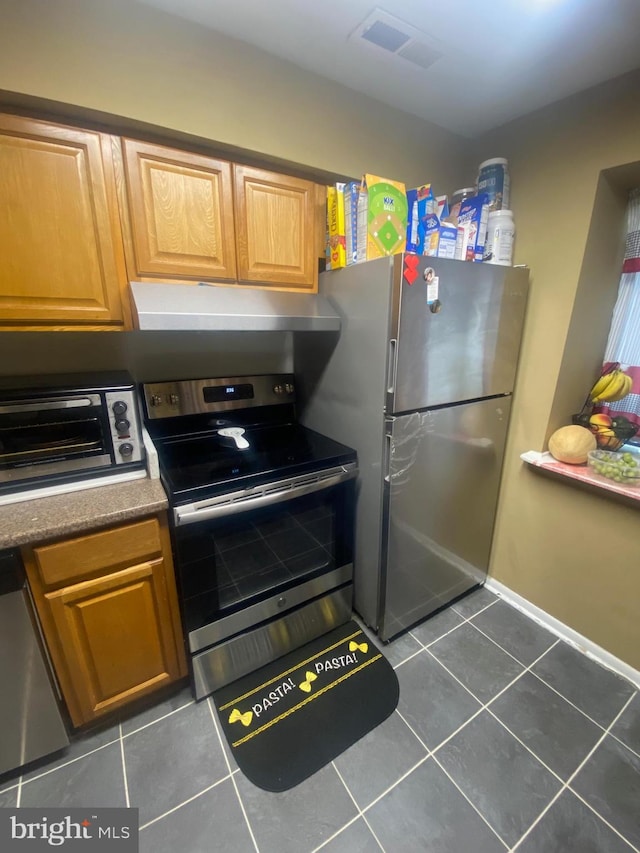 kitchen with stainless steel appliances and dark tile patterned floors