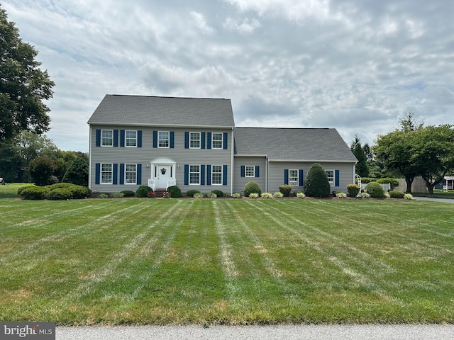 colonial home with a front lawn