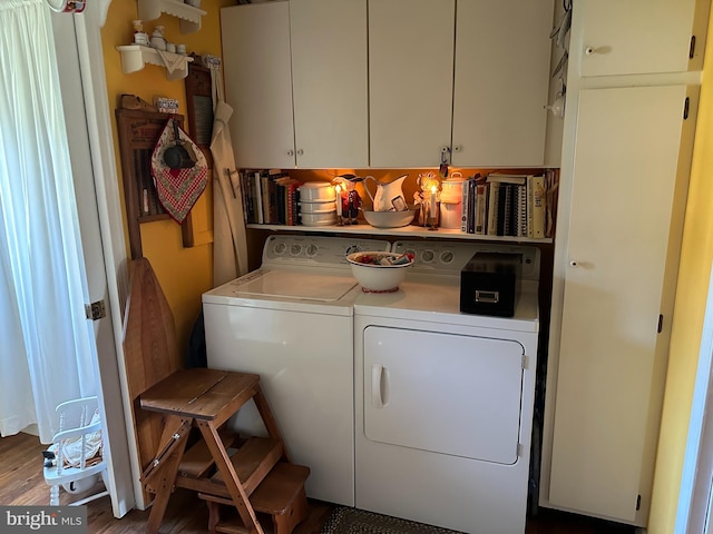 laundry area with cabinets, wood-type flooring, and washer and dryer