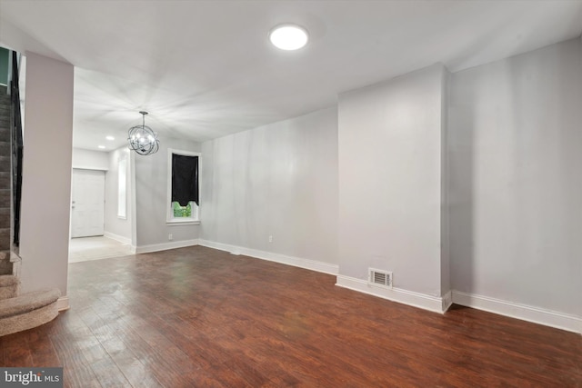 unfurnished room featuring a notable chandelier and hardwood / wood-style floors