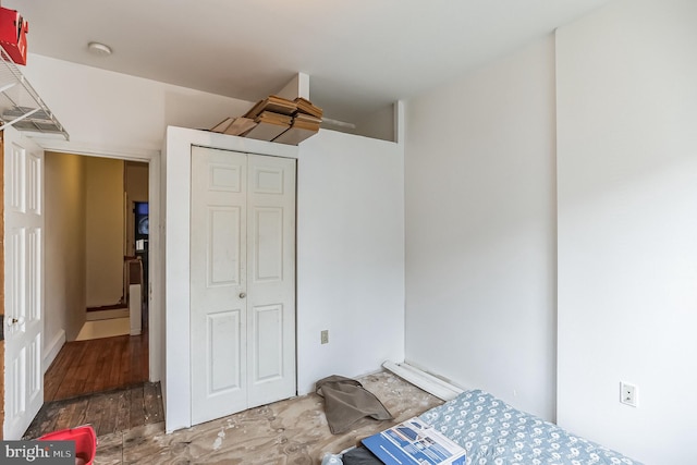 bedroom with wood-type flooring and a closet