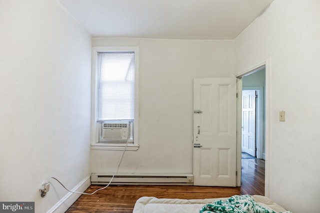 bedroom with cooling unit, a baseboard radiator, and wood-type flooring