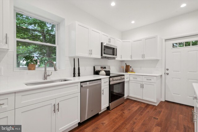 kitchen featuring stainless steel appliances, white cabinets, decorative backsplash, sink, and dark hardwood / wood-style floors