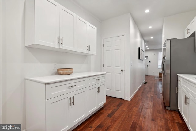 kitchen with white cabinets, dark hardwood / wood-style flooring, and stainless steel refrigerator