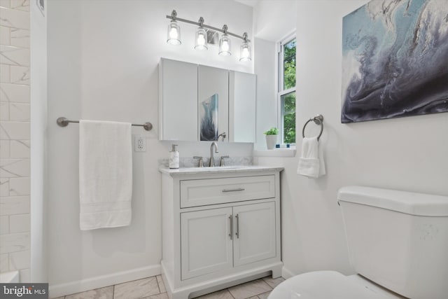 bathroom featuring tile patterned flooring, toilet, and vanity