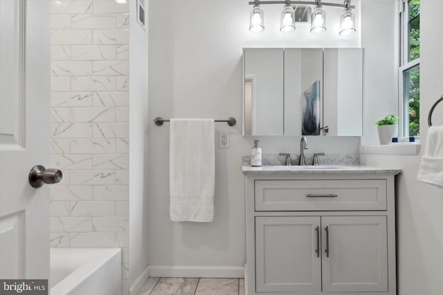 bathroom featuring tiled shower / bath and vanity