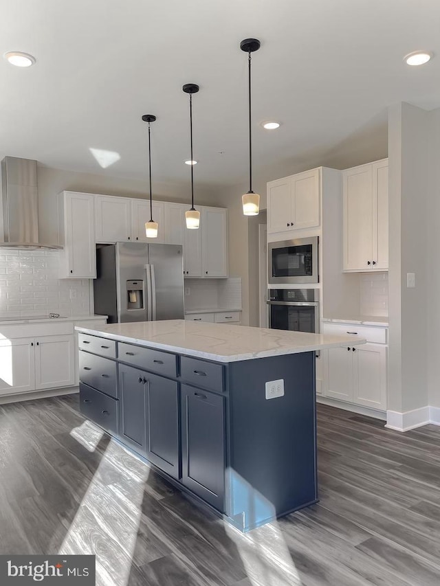 kitchen with white cabinetry, a center island, wall chimney exhaust hood, and appliances with stainless steel finishes