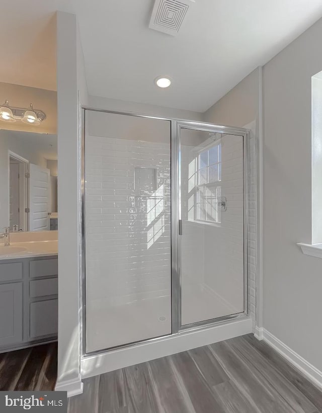 bathroom featuring a shower with door, wood-type flooring, and vanity