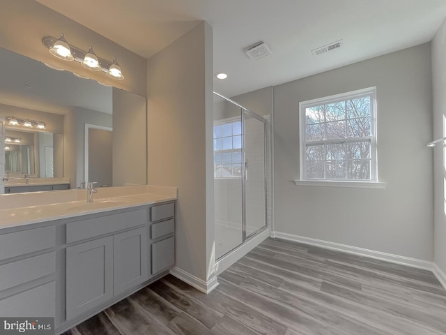 bathroom with vanity, hardwood / wood-style floors, and a shower with door