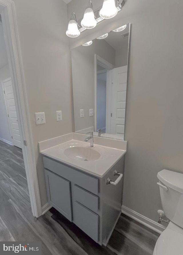 bathroom with vanity, hardwood / wood-style floors, and toilet