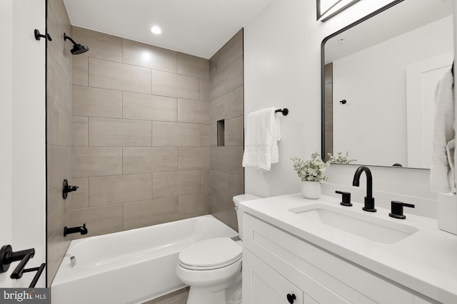 full bathroom with vanity, tiled shower / bath, and toilet