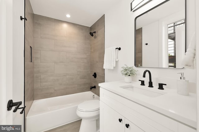 full bathroom with tiled shower / bath combo, vanity, and toilet