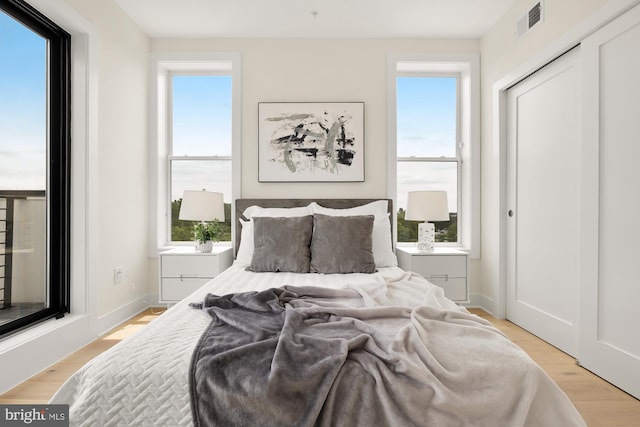 bedroom with light hardwood / wood-style flooring and a closet