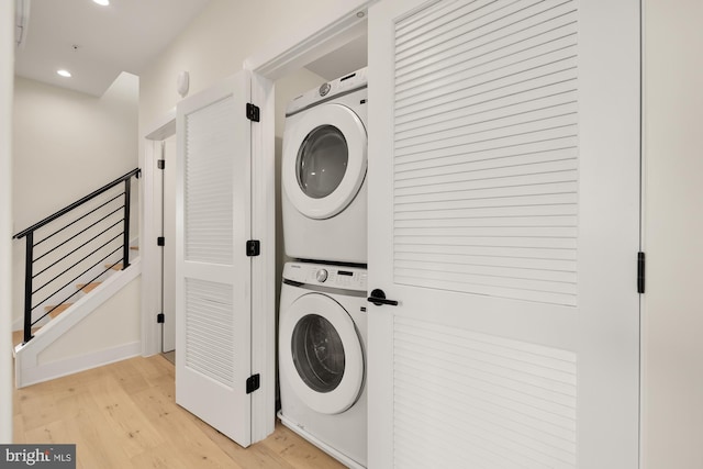 washroom featuring light hardwood / wood-style floors and stacked washer and clothes dryer