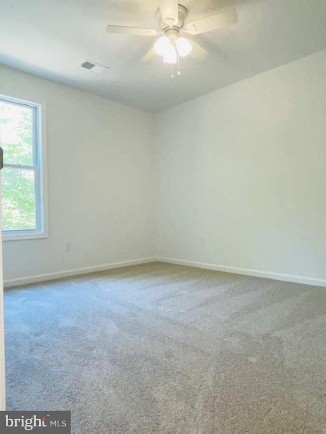 carpeted spare room featuring ceiling fan