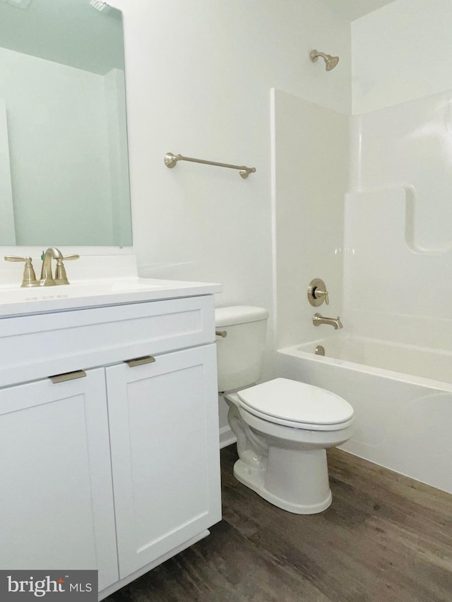 full bathroom featuring vanity, hardwood / wood-style floors, bathtub / shower combination, and toilet