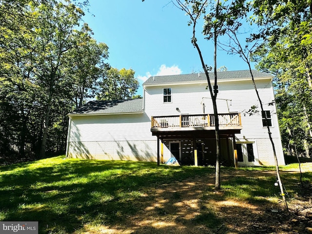 rear view of house featuring a wooden deck and a yard