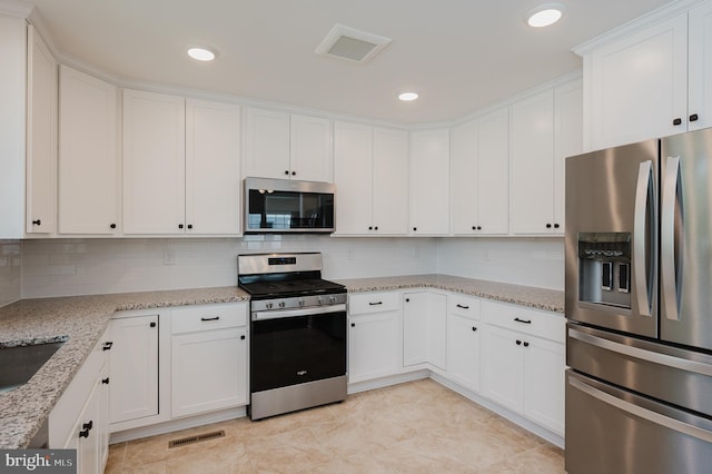 kitchen featuring tasteful backsplash, visible vents, white cabinets, and appliances with stainless steel finishes