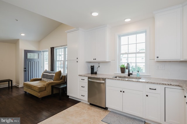 kitchen featuring lofted ceiling, sink, white cabinetry, tasteful backsplash, and stainless steel dishwasher