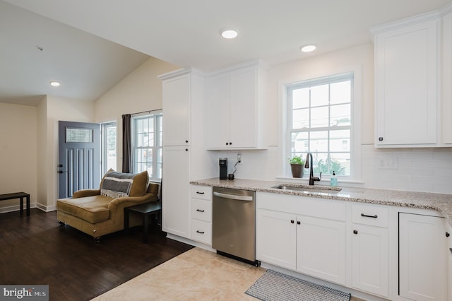 kitchen featuring stainless steel dishwasher, white cabinets, a healthy amount of sunlight, and a sink