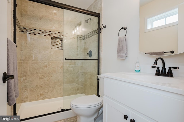 bathroom with a shower with door, vanity, and toilet