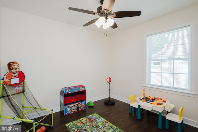 recreation room with ceiling fan, baseboards, and wood finished floors