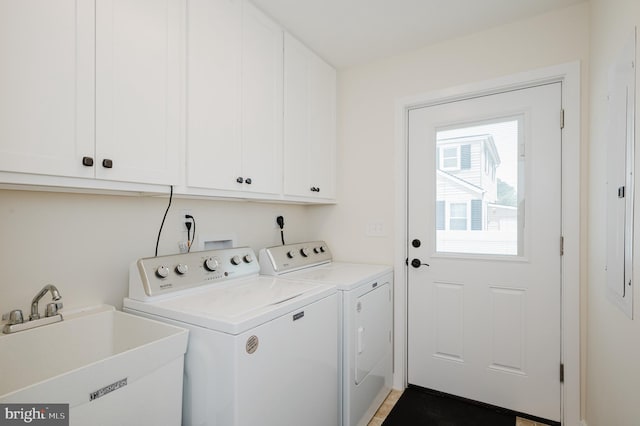 clothes washing area featuring a sink, cabinet space, and washer and dryer