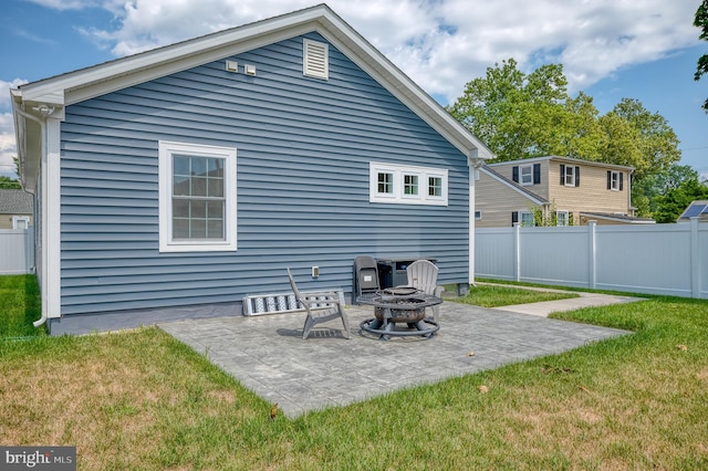 rear view of house featuring a patio area, a yard, fence, and an outdoor fire pit