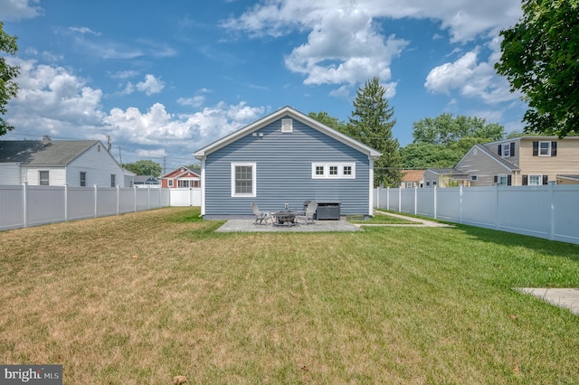 rear view of property featuring a patio, a yard, central AC, and a fire pit