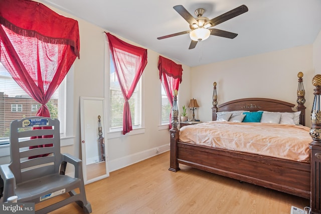 bedroom with light wood-type flooring, ceiling fan, and multiple windows