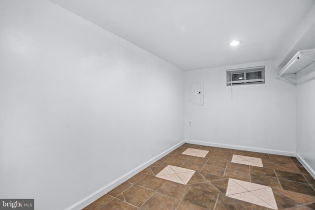 unfurnished room featuring dark tile patterned floors and electric panel