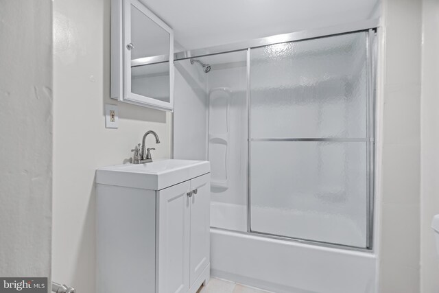 bathroom with tile patterned floors, vanity, and shower / bath combination with glass door