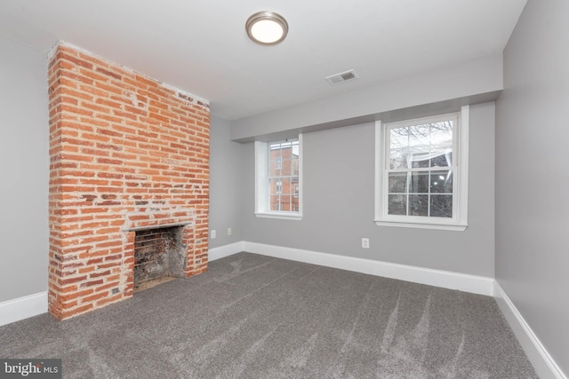 unfurnished living room with a brick fireplace and carpet floors